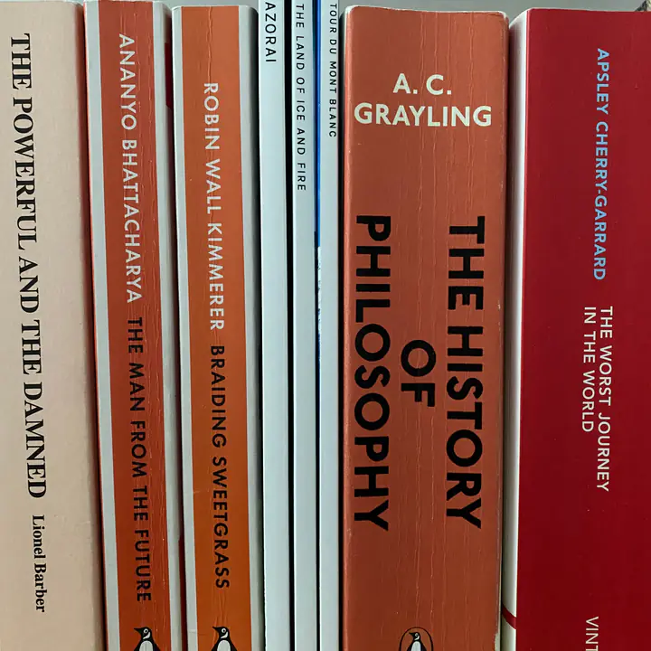 Printed kikōbook travel books on a shelf between paperbacks